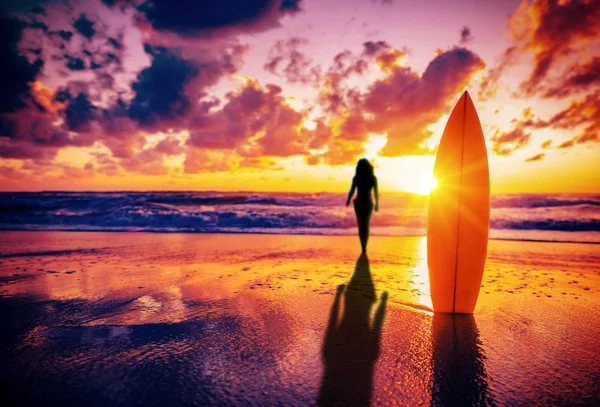 Surfplank op het strand bij zonsondergang — Stockfoto