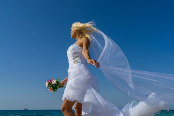 Joven novia en boda drees divertirse en la playa — Foto de Stock