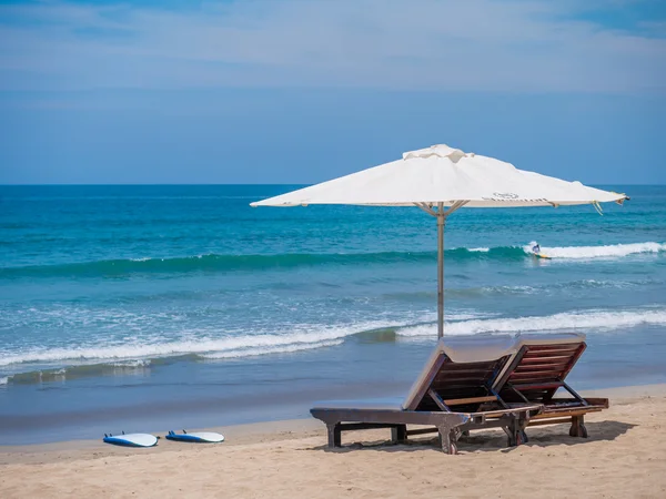 Bedden en een paraplu op een strand — Stockfoto