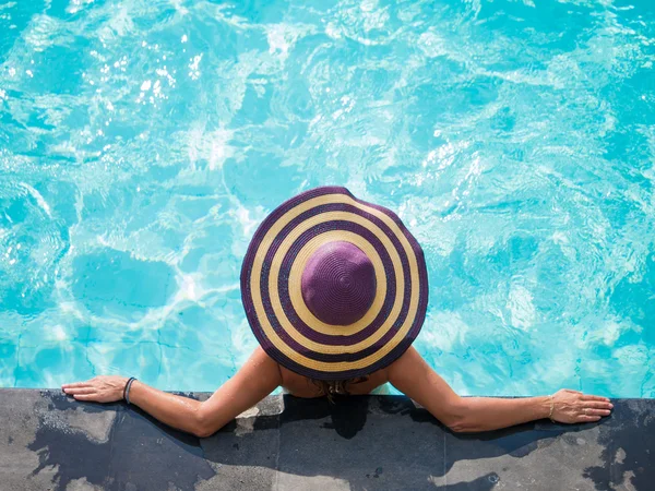 Uma menina está relaxando em uma piscina — Fotografia de Stock