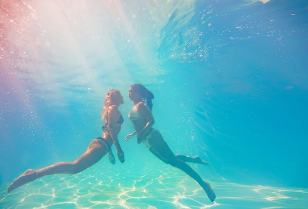 Two young women swimming underwater — Stock Photo, Image