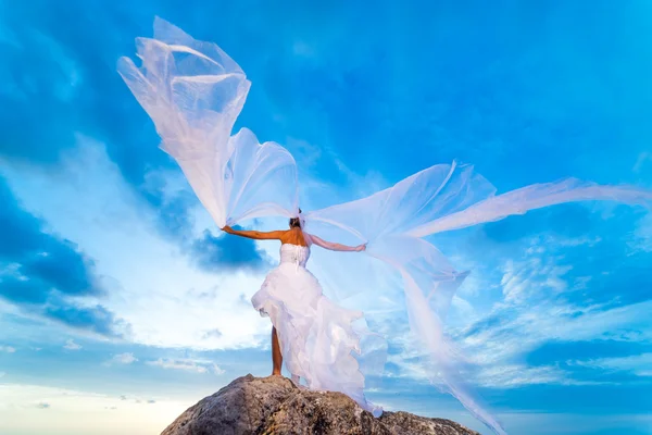 Jeune mariée au bord de la mer au coucher du soleil — Photo