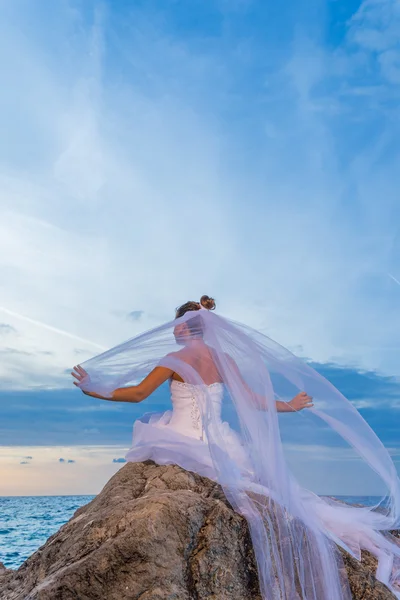 Jovem noiva junto ao mar ao pôr do sol — Fotografia de Stock