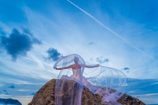 Молодая невеста на берегу моря на закате
