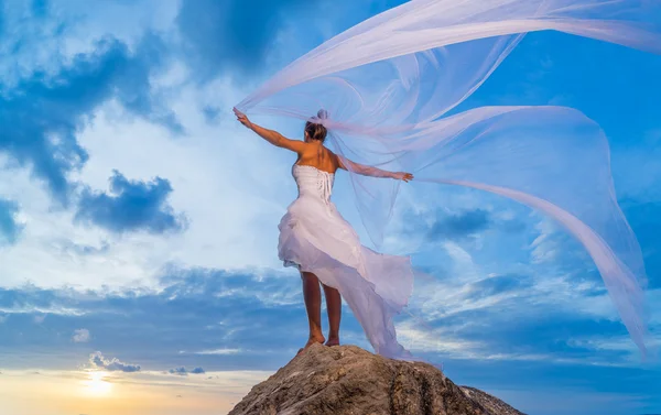 Jeune mariée au bord de la mer au coucher du soleil — Photo