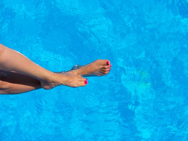 legs of woman lying near the pool . Beautiful female a foot