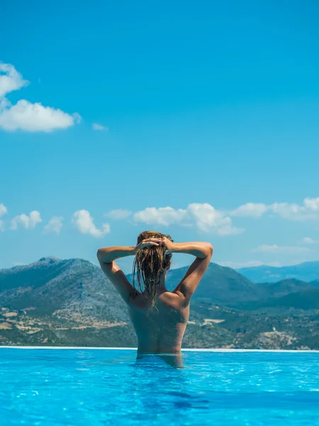 Afbeelding van een vrouw in zwembad kijken naar de zee — Stockfoto