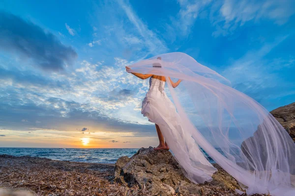 Joven novia junto al mar al atardecer — Foto de Stock