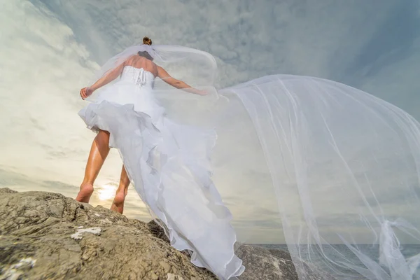 YOung bride by the sea at sunset Stock Image