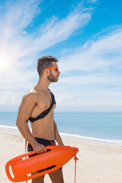 Lifeguard on duty keeping a buoy — Stock Photo, Image