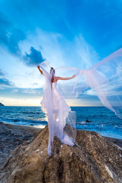 Jeune mariée au bord de la mer au coucher du soleil — Photo