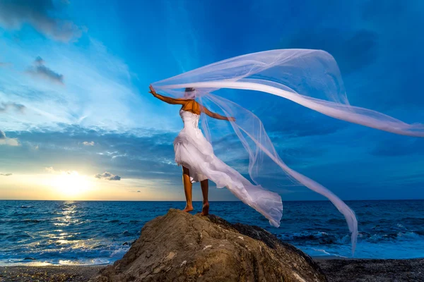 Jeune mariée au bord de la mer au coucher du soleil — Photo