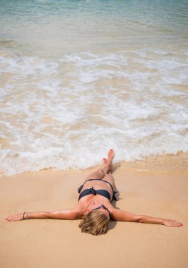 Güzel genç kadın portre tropik sahilde döşeme. 