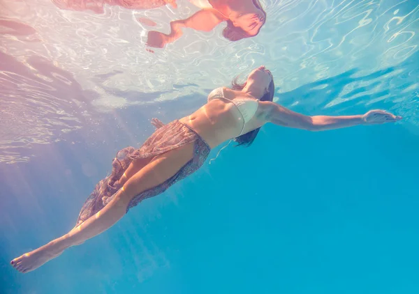 Femme nageant sous l'eau dans une piscine — Photo