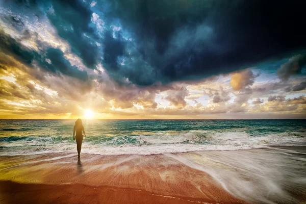 Hermosa silueta de mujer joven en el mar al atardecer — Foto de Stock