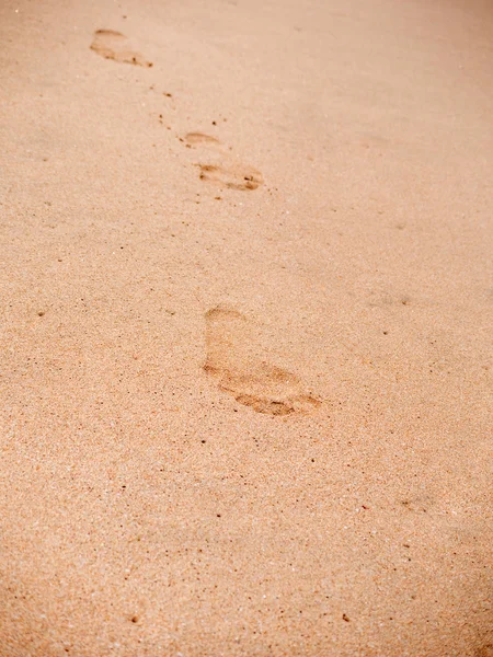 Mänskliga fotavtryck på strand sanden leder bort — Stockfoto