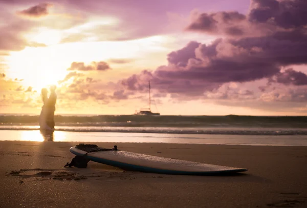 Mariée et marié sur une plage tropicale avec le coucher de soleil dans le backg — Photo