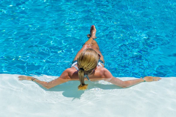 Une fille se relaxe dans une piscine — Photo