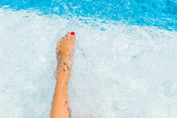 Flickans ben i poolen att göra stänk — Stockfoto