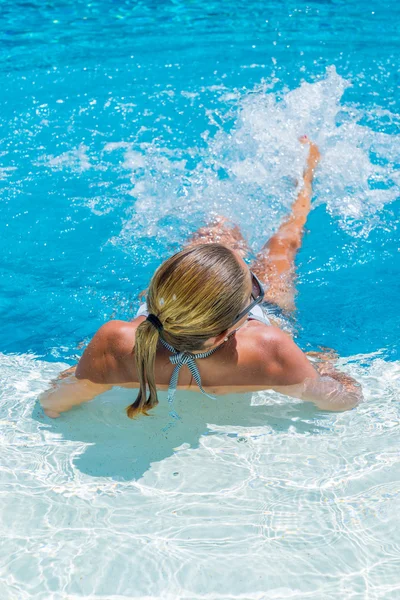 Uma menina está relaxando em uma piscina — Fotografia de Stock