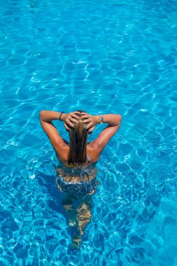 bir kızın rahatlatıcı bir yüzme havuzunda