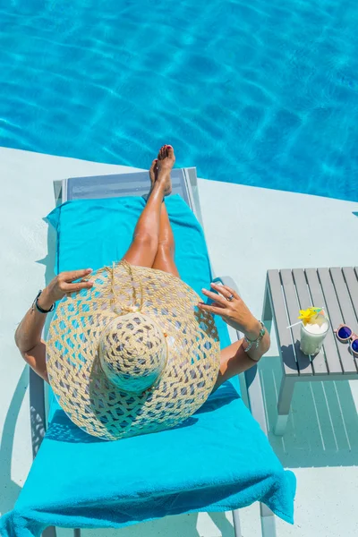 Woman relaxing by the swimming pool — Stock Photo, Image