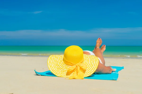 Femme en bikini jaune couchée sur une plage tropicale — Photo