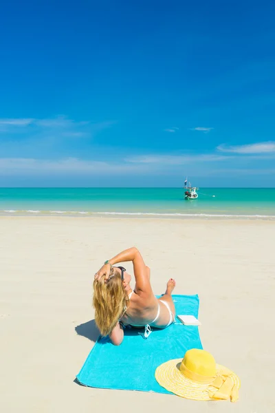 Mujer en bikini amarillo acostada en la playa tropical —  Fotos de Stock