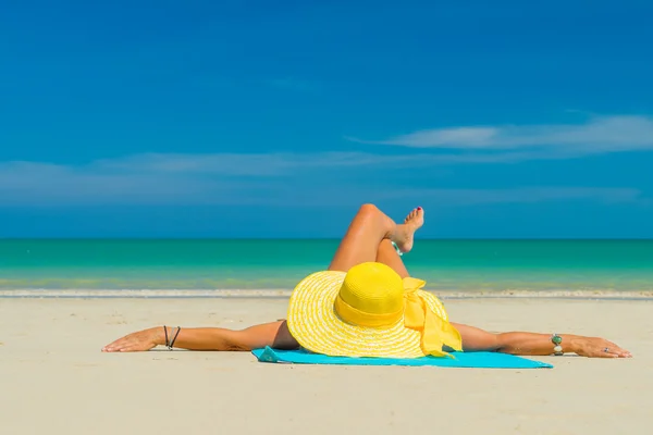 Mujer en bikini amarillo acostada en la playa tropical —  Fotos de Stock