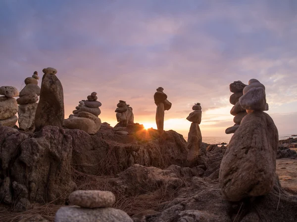 Pirámide de piedras sobre arena que simboliza zen, armonía, equilibrio. Océano — Foto de Stock