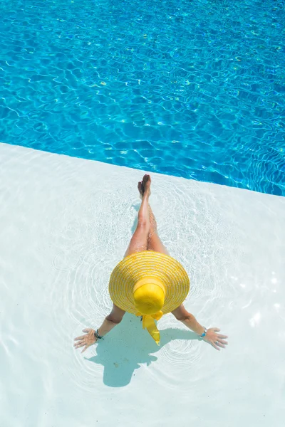 Femme portant un grand chapeau relaxant à la piscine — Photo