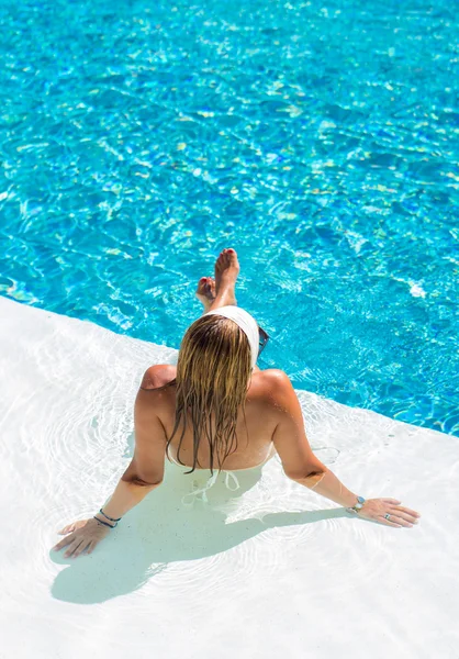 Uma menina está relaxando em uma piscina — Fotografia de Stock