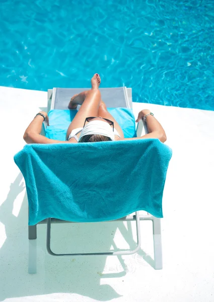 Mujer en sombrero relajación en la cama de la piscina —  Fotos de Stock