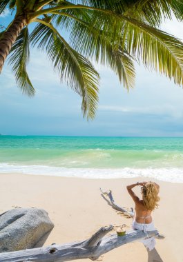 Kumsalda dinlenen bir kadın 