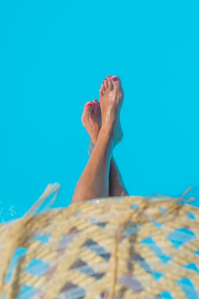 Donna irriconoscibile in grande cappello rilassante sulla piscina — Foto Stock