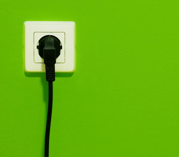 Cable en conector enchufe en pared verde — Foto de Stock