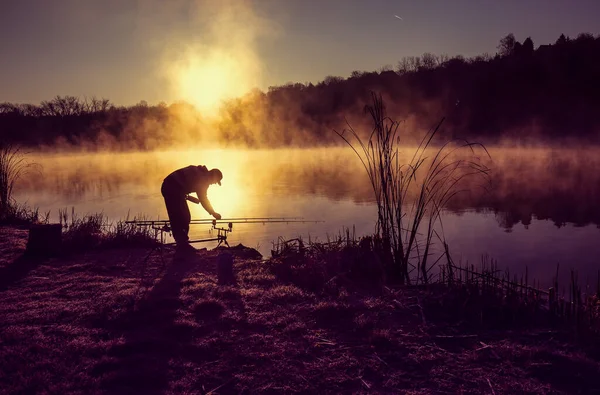 朝の時間に湖畔で漁師のシルエット — ストック写真