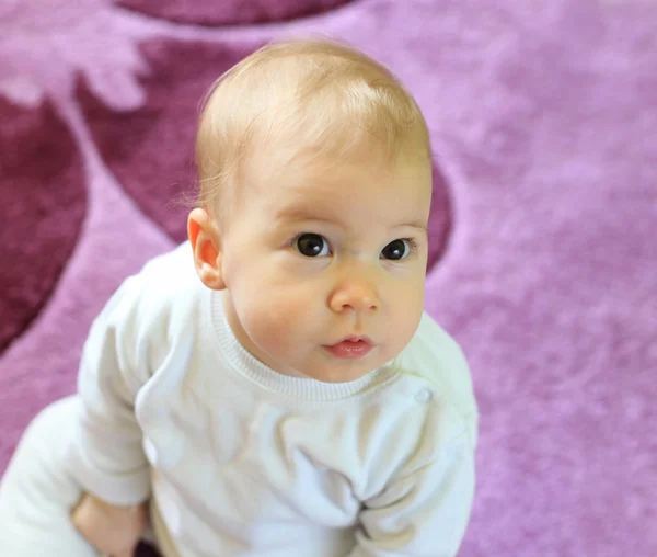 Young cute baby sitting on floor — Stock Photo, Image