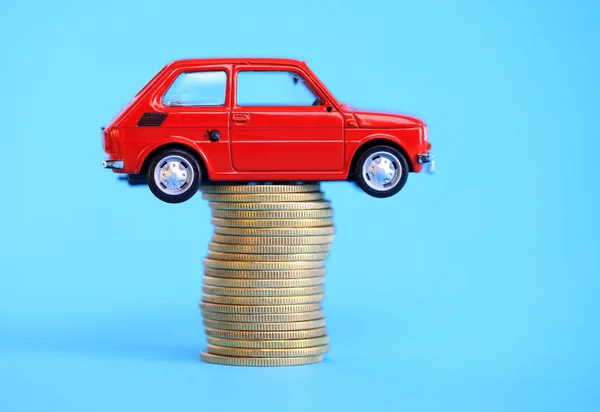 Carro em miniatura vermelho na pilha de moedas — Fotografia de Stock