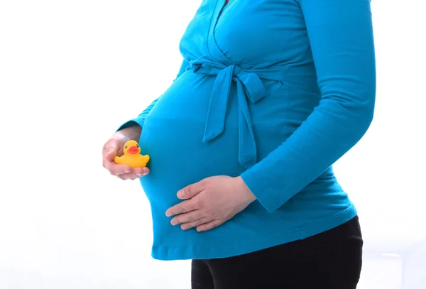 Zwangere vrouw speelgoed in de hand houden — Stockfoto