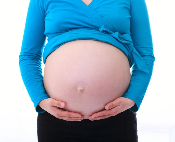 Zwangere vrouw houdt handen op buik — Stockfoto