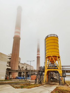 Sisli havada bacası olan elektrik santrali.