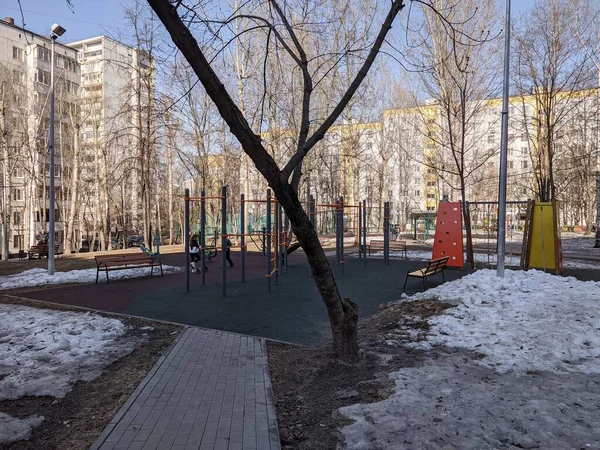 Un sentiero con alberi sul lato vicino al parco giochi sportivo — Foto Stock