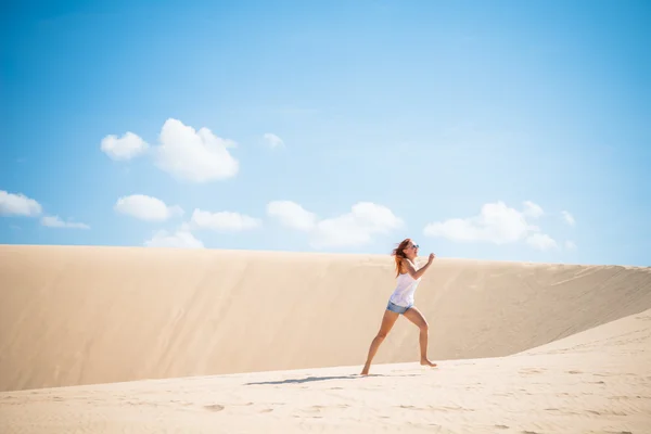 Dunes üzerinde çalışan genç bir kadın — Stok fotoğraf
