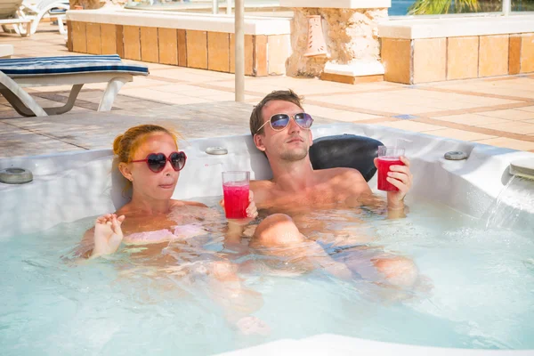 Jeune couple relaxant dans la piscine jacuzzi — Photo