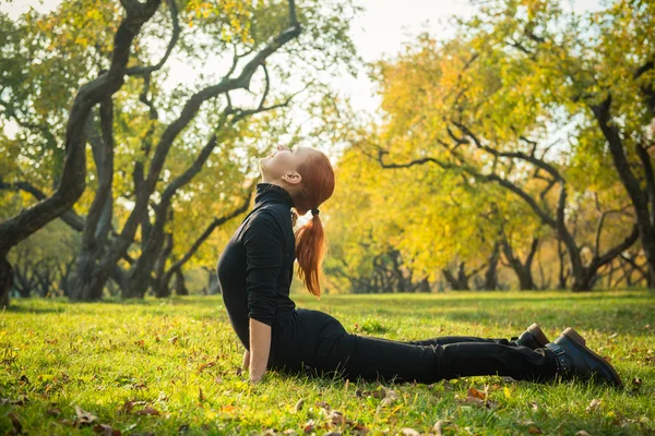 Mujer haciendo yoga en el parque de otoño — Foto de Stock