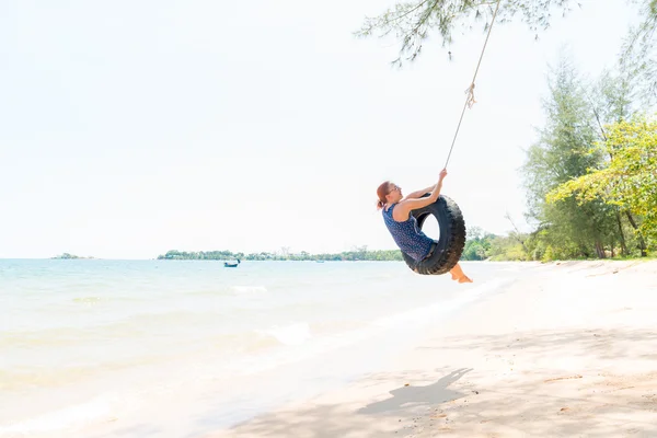 Happy woman on tire swing — Stock Photo, Image