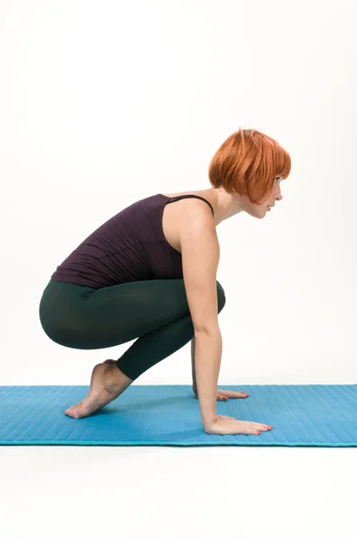 Yoga posando sobre un fondo gris de estudio —  Fotos de Stock