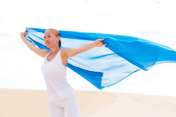 Mavi eşarp uçan ile genç bir kadın — Stok fotoğraf