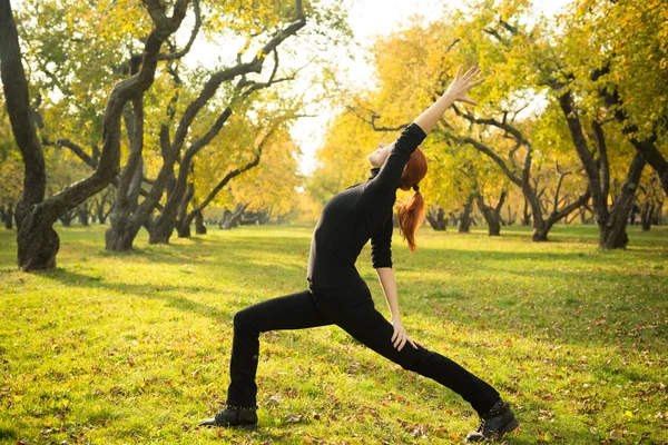 Wanita melakukan yoga di taman musim gugur — Stok Foto